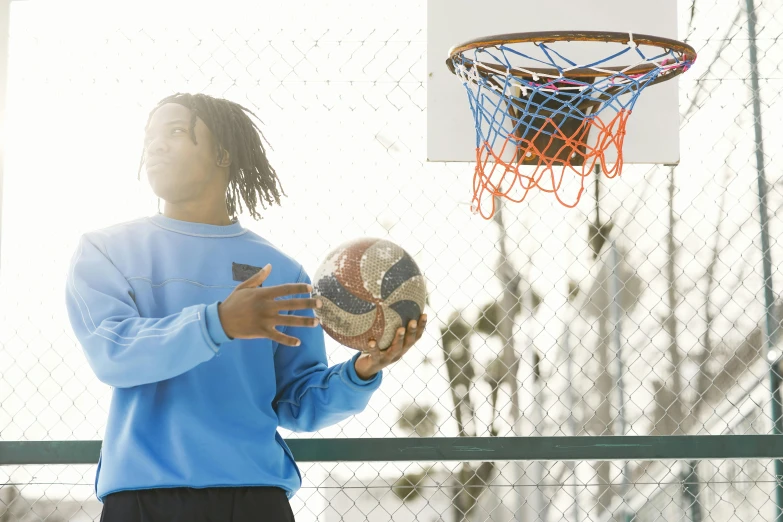 a man holding a ball and basketball while standing on a court