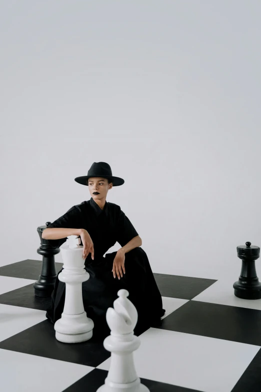a man that is sitting next to a giant chess