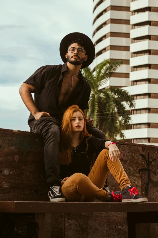 two women sitting on a wooden crate and man standing behind them