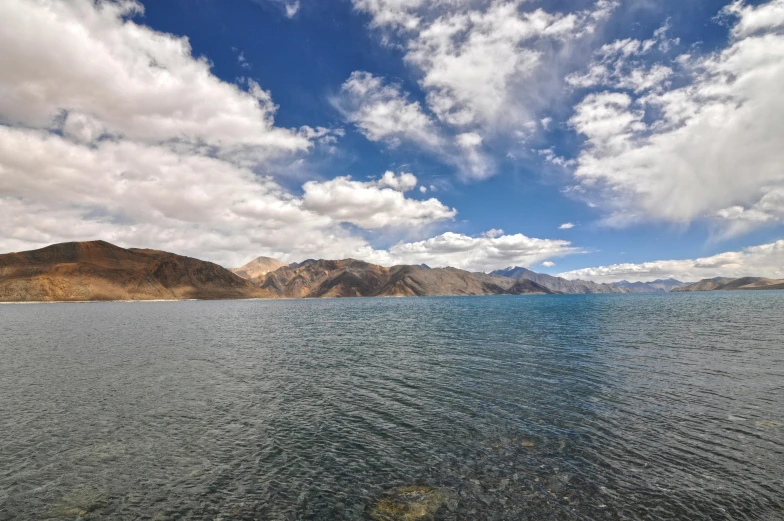 there are many mountains in the background on the water