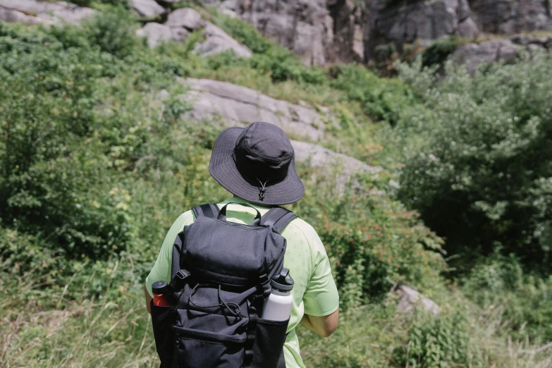 a man with backpack walking up a hill