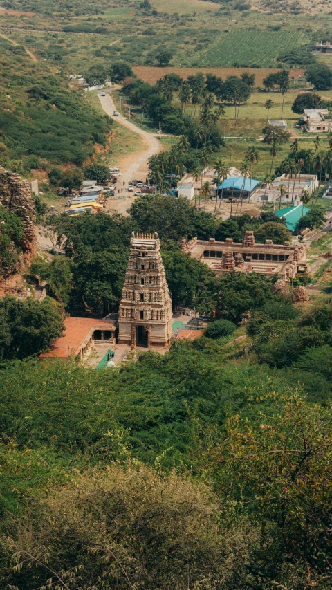 aerial view of a temple with trees and dirt road near the ground
