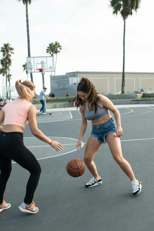 a woman holding a basketball ball in front of another person