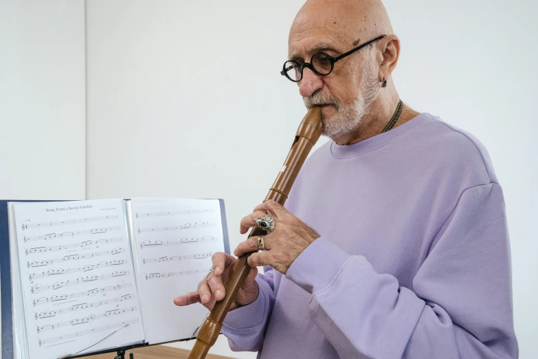 an older man playing an flute and music score