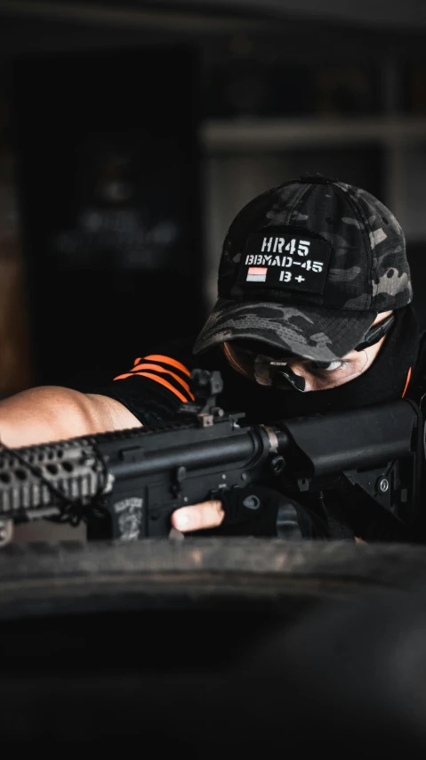 a man wearing a hat while holding a machine gun