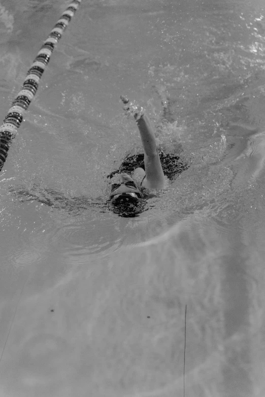 a woman swimming in a pool near the edge of a large pool