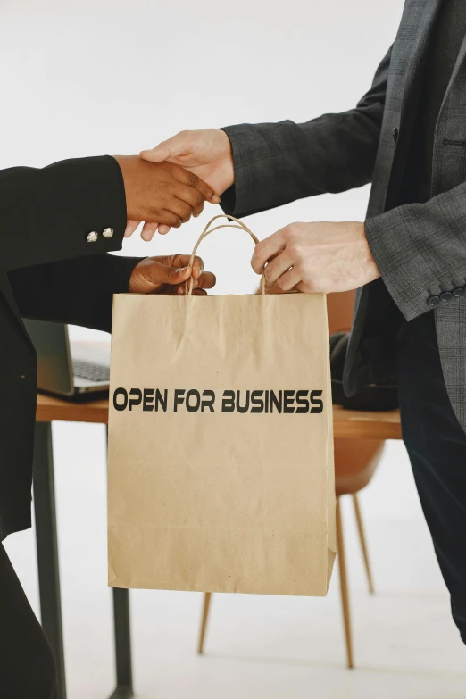 a person in business attire handing an open - to - business bag