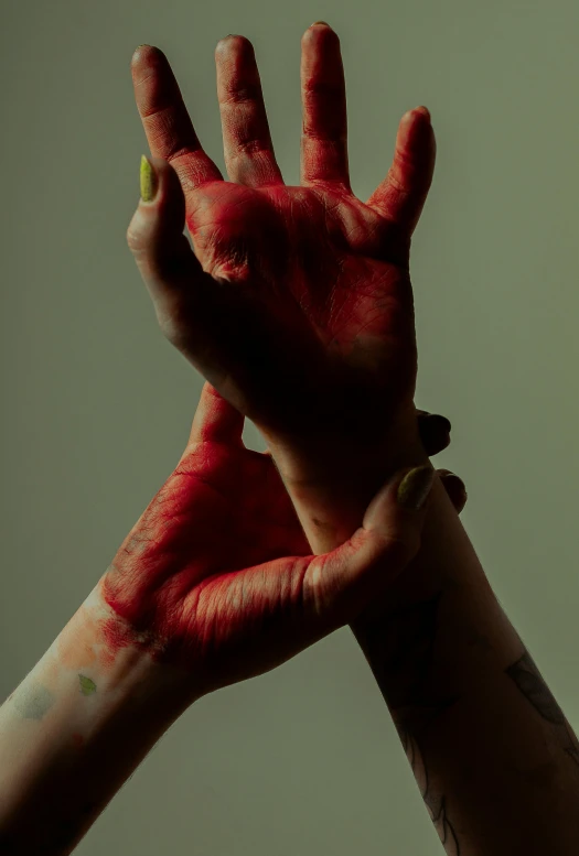 someone's hand with their fingers covered in red paint