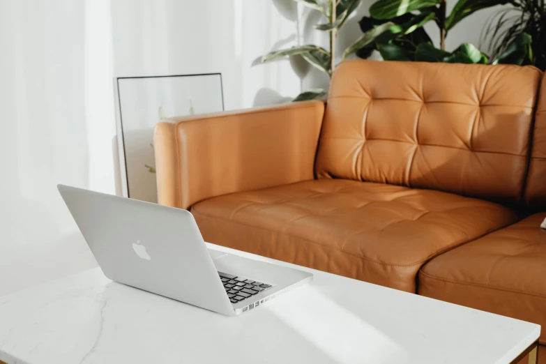 a white table top sitting next to a brown couch