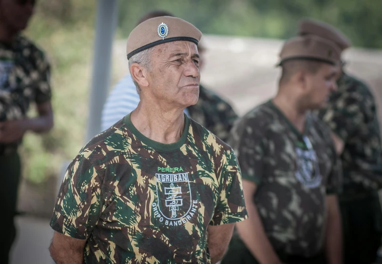 a man with a green and brown camo shirt and a hat