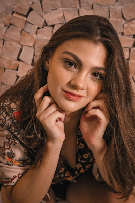 a woman with long hair sitting on a brown and white floor