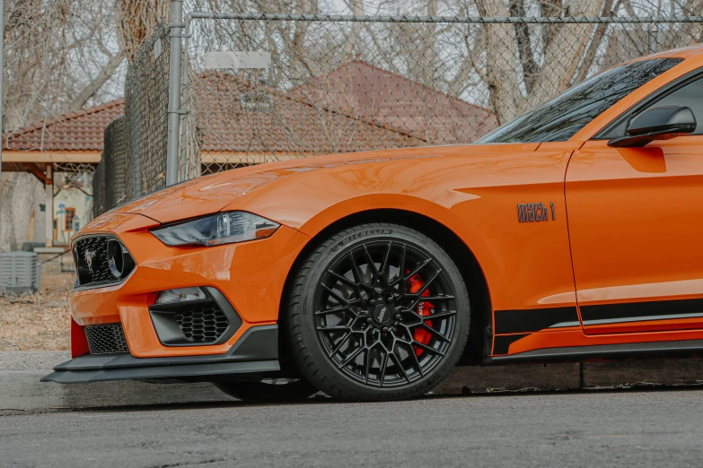 an orange sports car sits in a lot