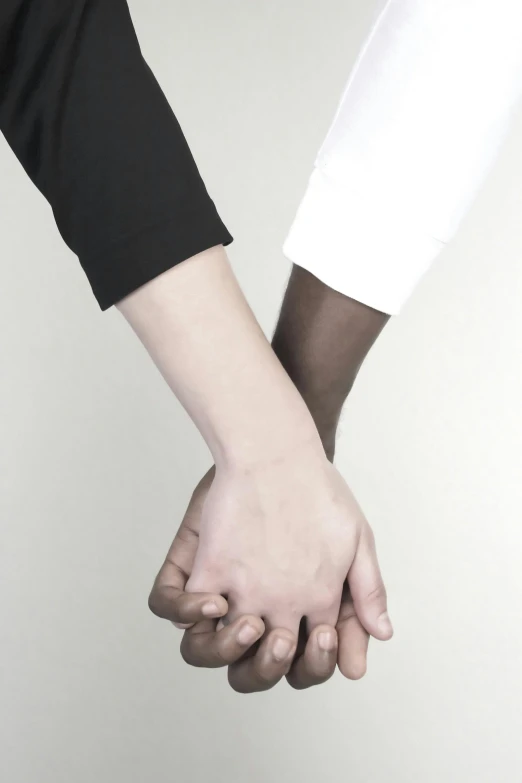 two people are holding hands over each other