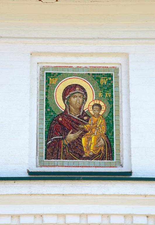 a stained glass window with an icon of a person holding a child