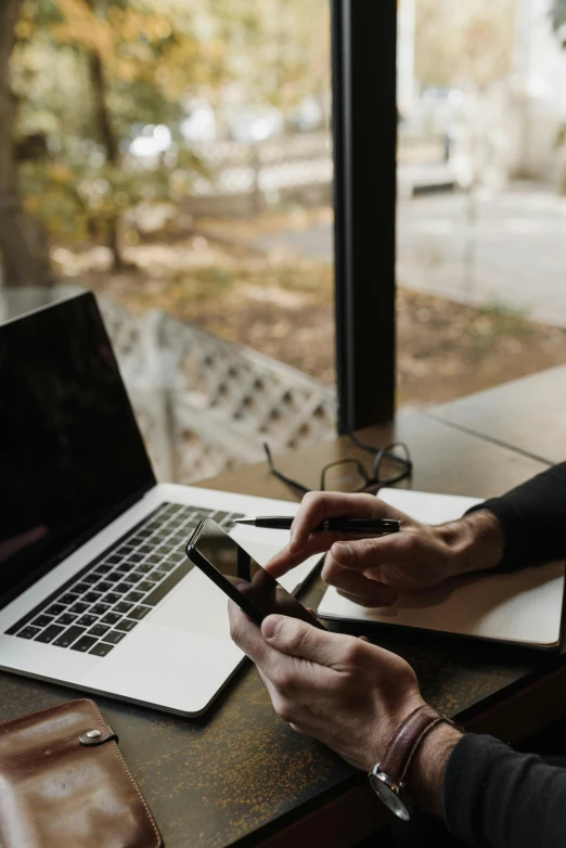 a person working on their cell phone at a table