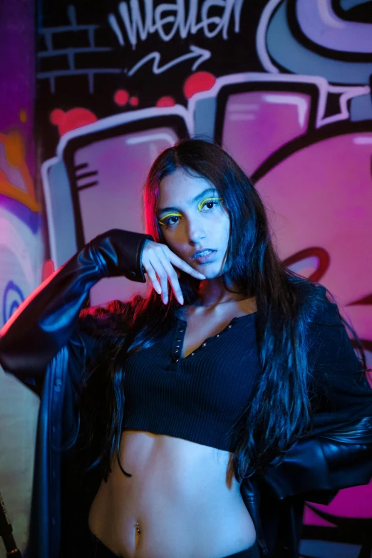 a woman in black standing in front of graffiti