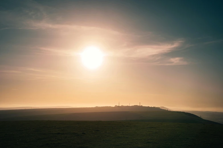 the sun shining down on an area of land with grass