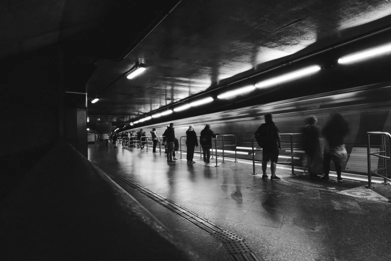 people walking in a long line in an subway