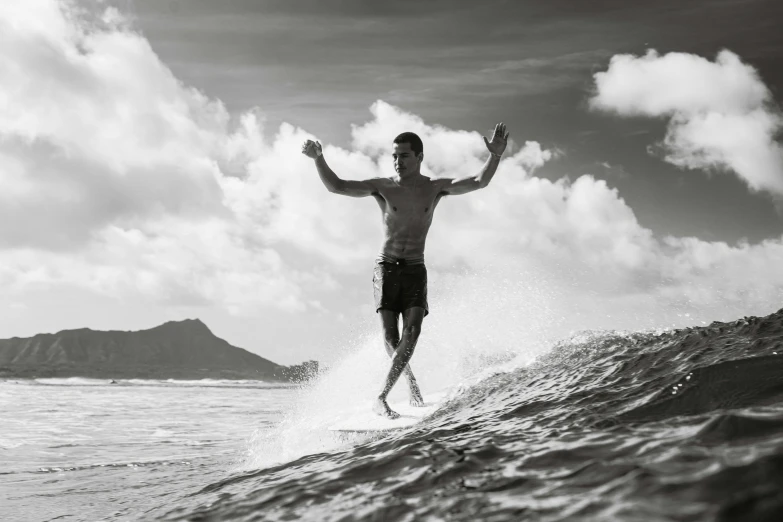a man surfing on a wave in a black and white po