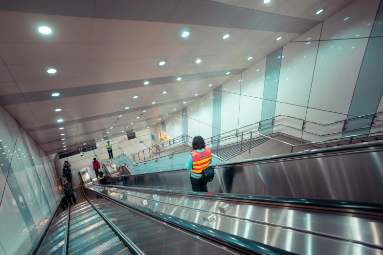 people in vests are on an escalator