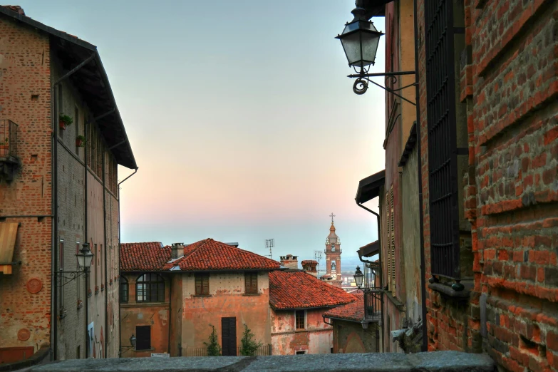 view over an alley in old rome with a clock tower