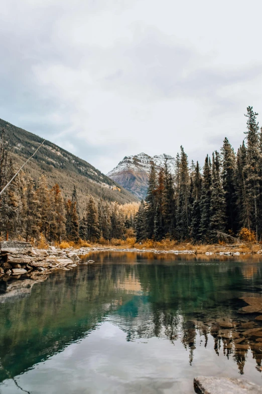 mountains are reflected in the clear waters on this mountain stream