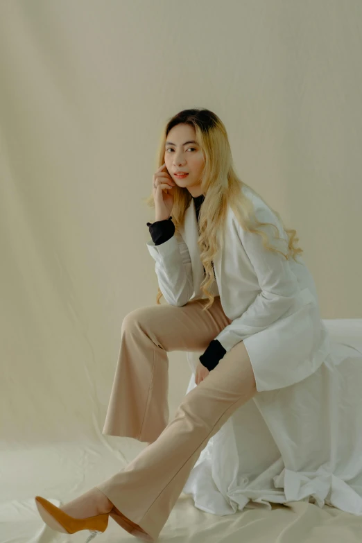 a female sitting on a bed in high heels