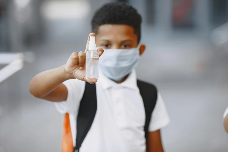 a  in a face mask holding an empty glass