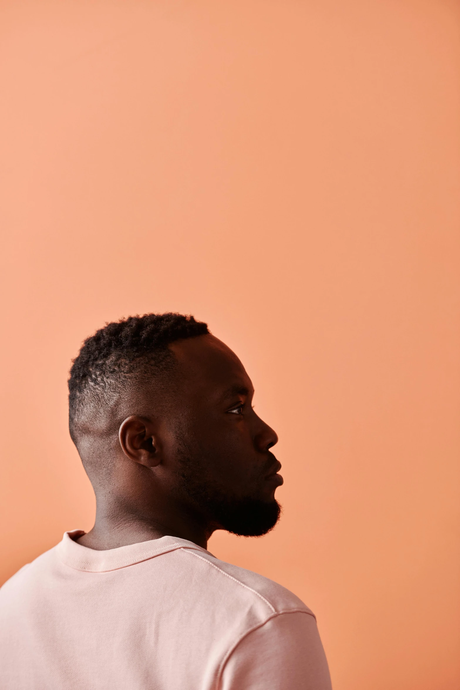 a black man looking away while wearing a sweater