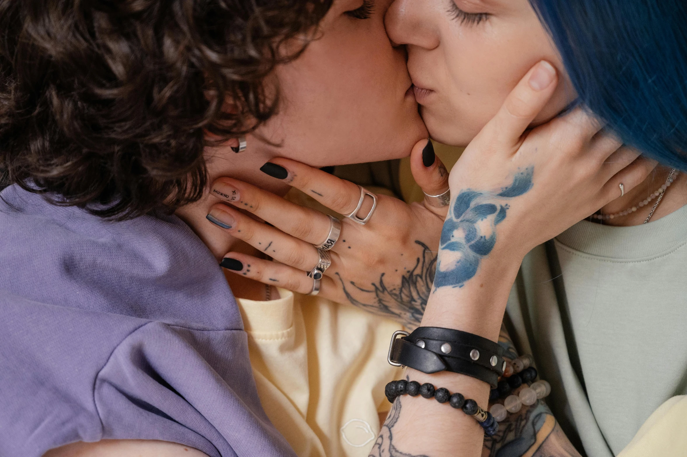 two women with tattoos and piercings kissing on each other