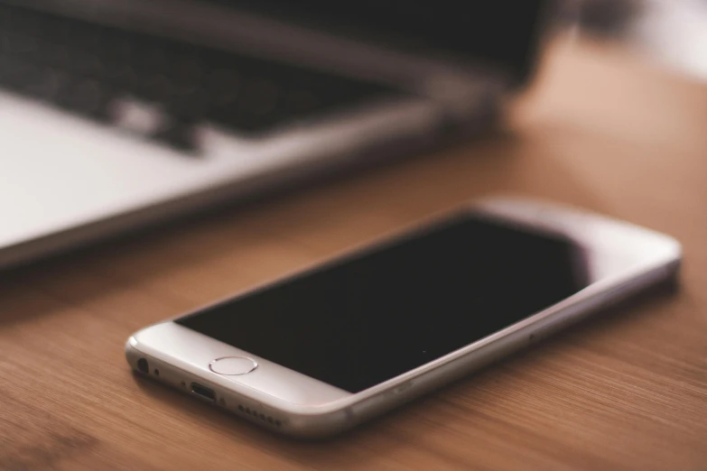 a cell phone sitting on top of a wooden table