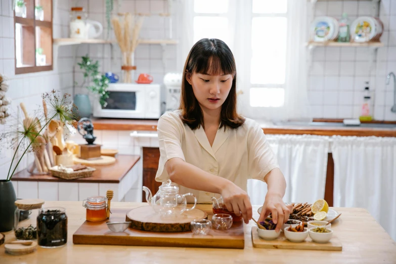 a woman in a kitchen preparing food on a  board