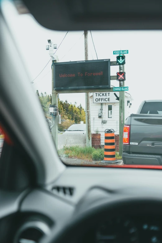 two cars stopped at an intersection as they are seen through the rear view mirror