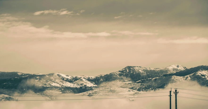 a mountain range covered with clouds and snow