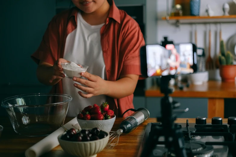 a woman in red shirt preparing food at a kitchen counter