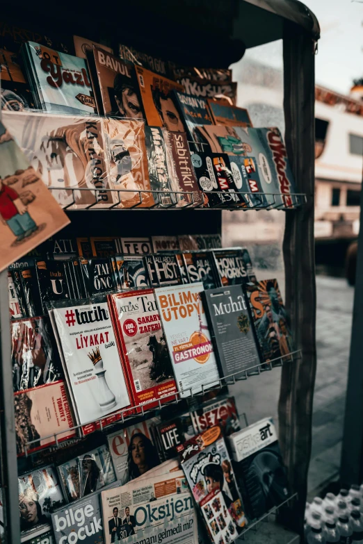 there are magazines hanging on a wooden shelf