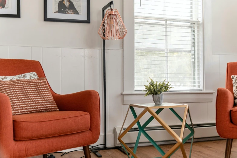 an orange chair and footstool are sitting in the corner of this white living room