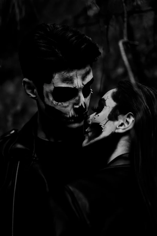 a black and white pograph of a woman with skull makeup and a man wearing skulls