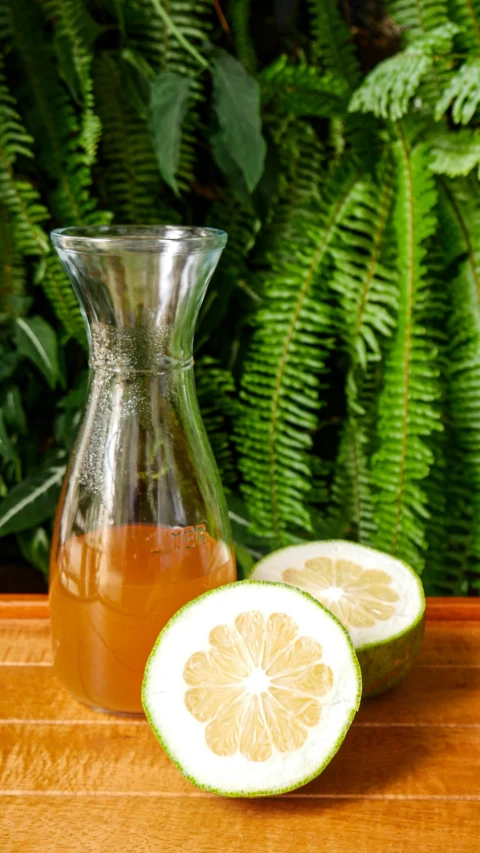 a pitcher filled with liquid next to cut up lemons