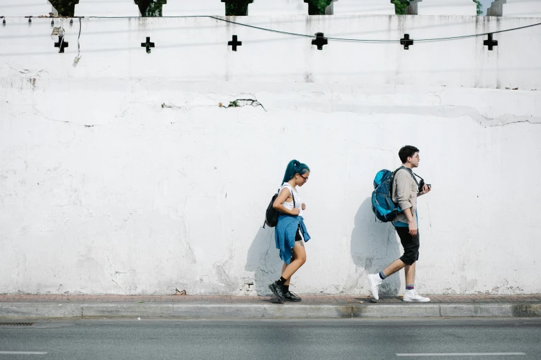 two s walking down the street, both with backpacks