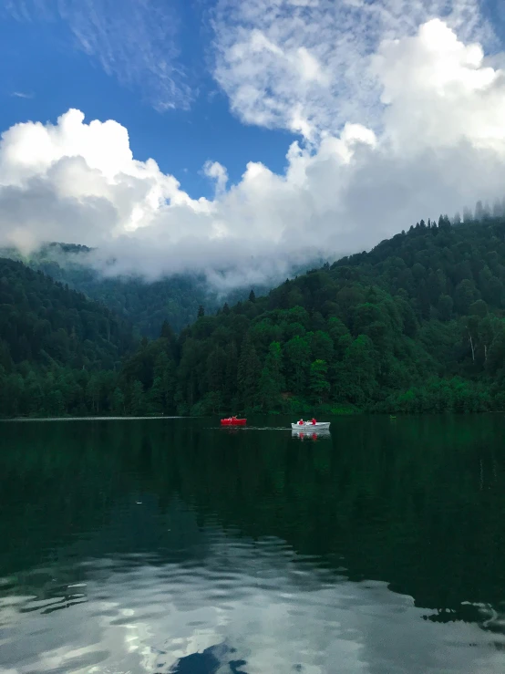 a boat sailing on the water near many mountains