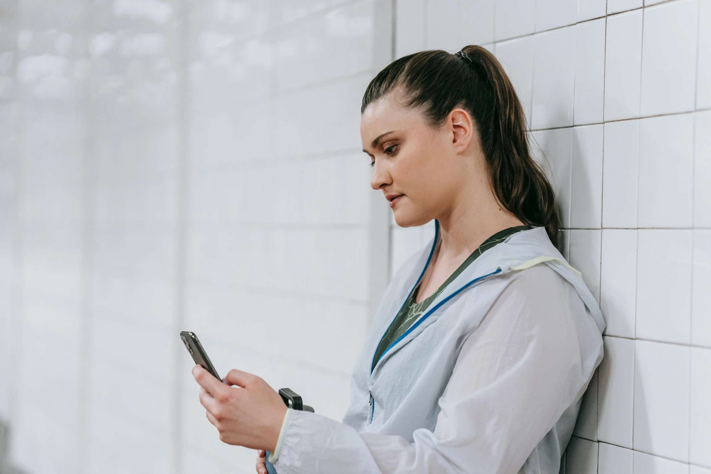 the woman is standing on her cell phone