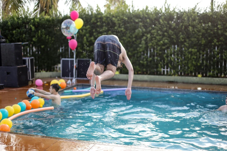 people jump into a pool with inflatable balls