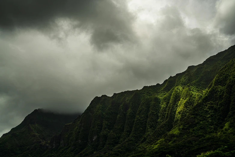 some tall green mountains and a cloudy sky