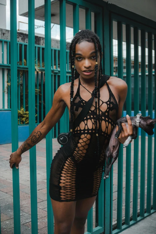 a woman is holding onto a gate and posing for a po