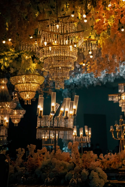 a chandelier filled with lit up candles and flowers