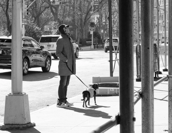 a man with a dog walks down a street