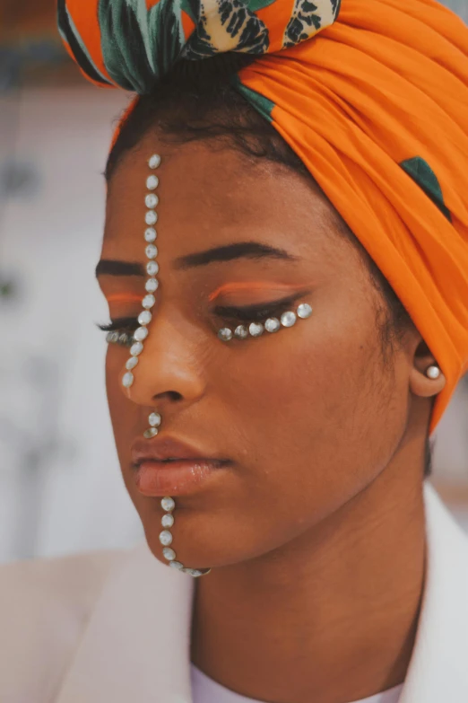 a woman wearing a orange turban with lots of beads