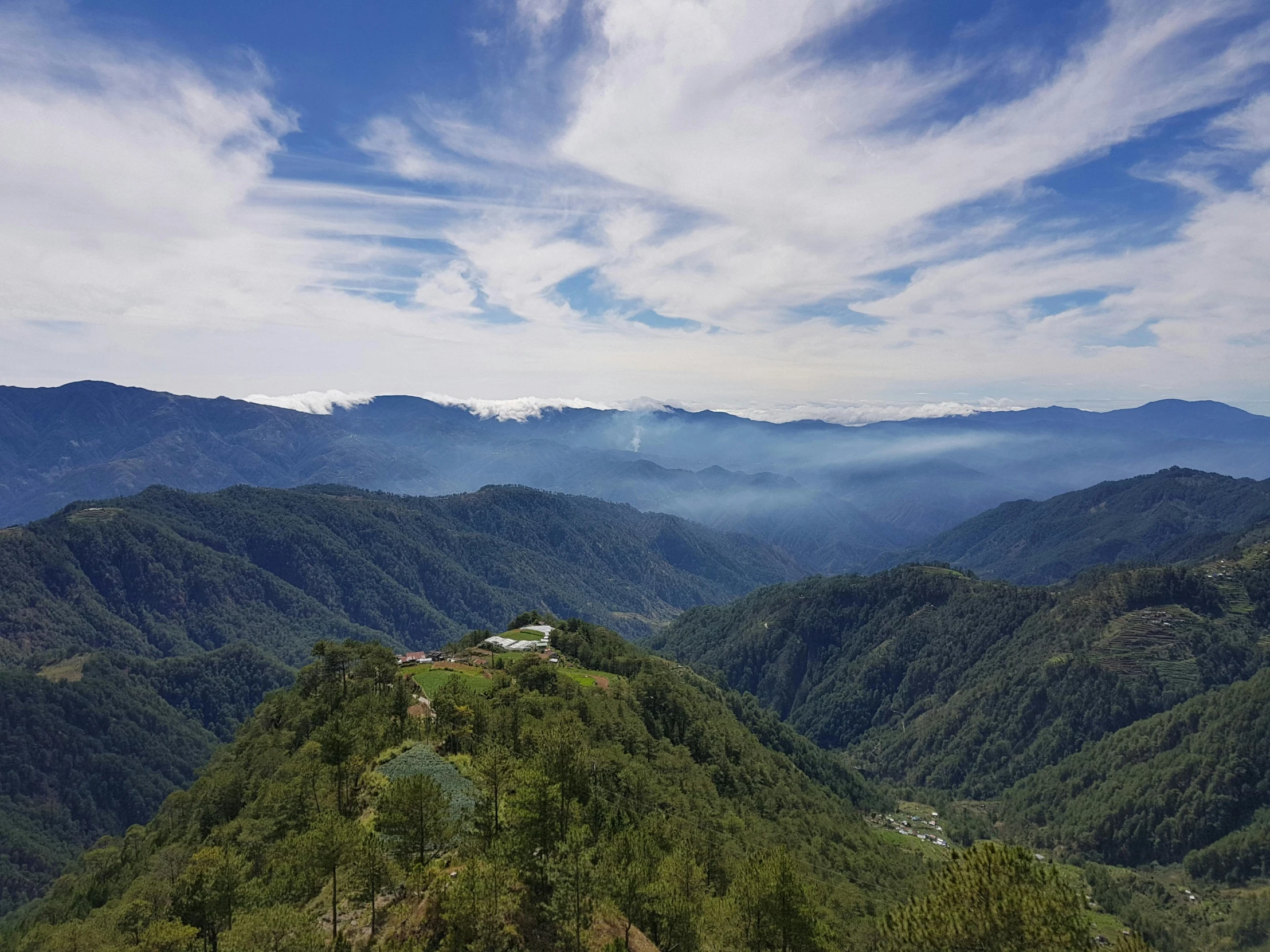 the tops of mountains and houses on a grassy field