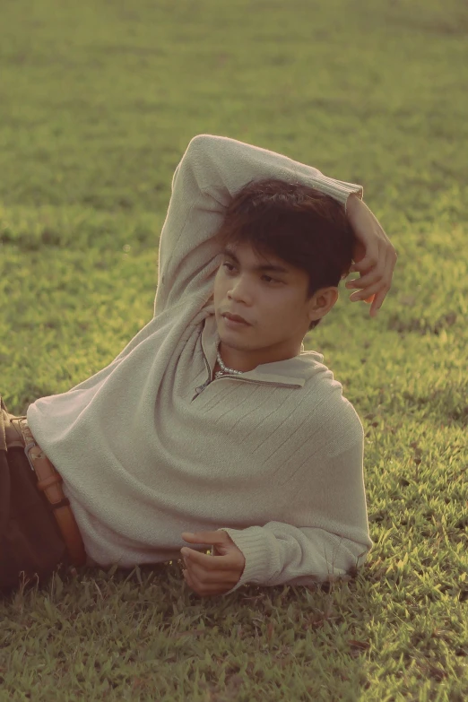 a person laying in the grass with a remote